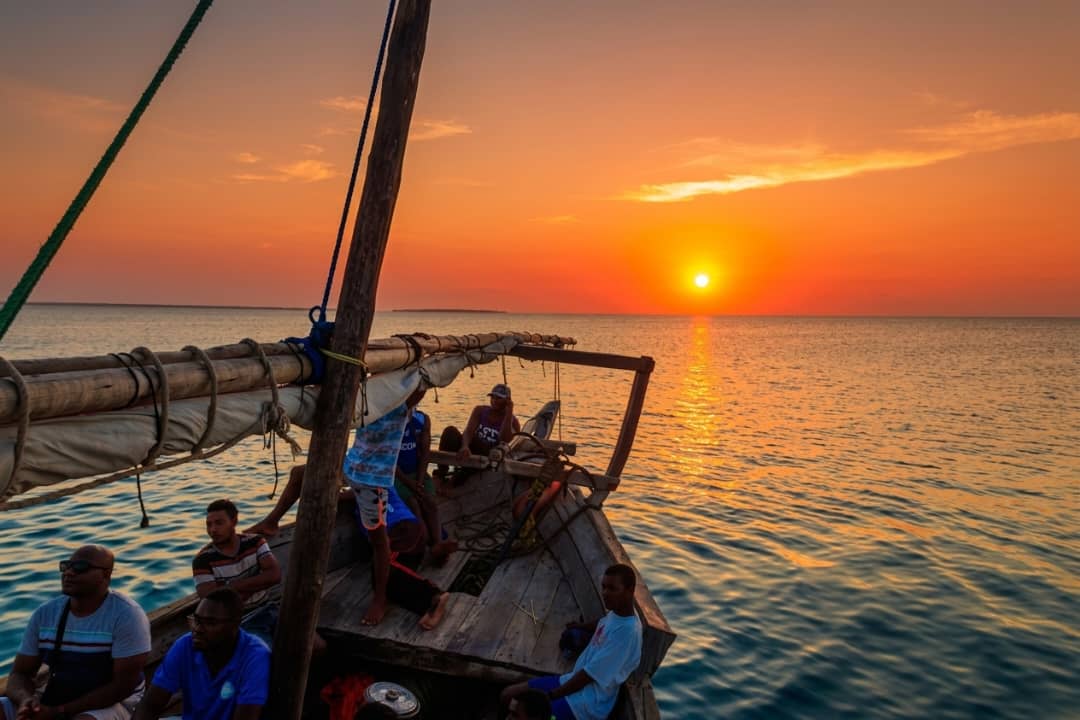 Traditional wooden dhow sailing on the Indian Ocean during a golden sunset